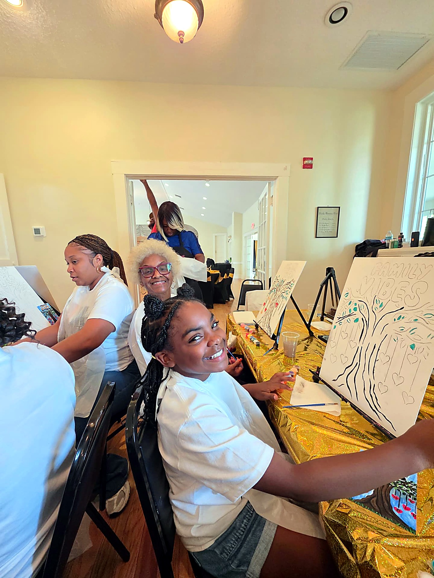 Three generations of Chandlers painting Family Vibes canvases together