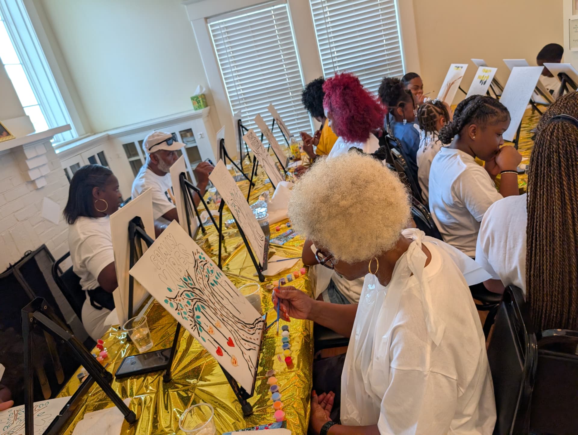 Generations of Chandlers painting along the gold-draped paint party table