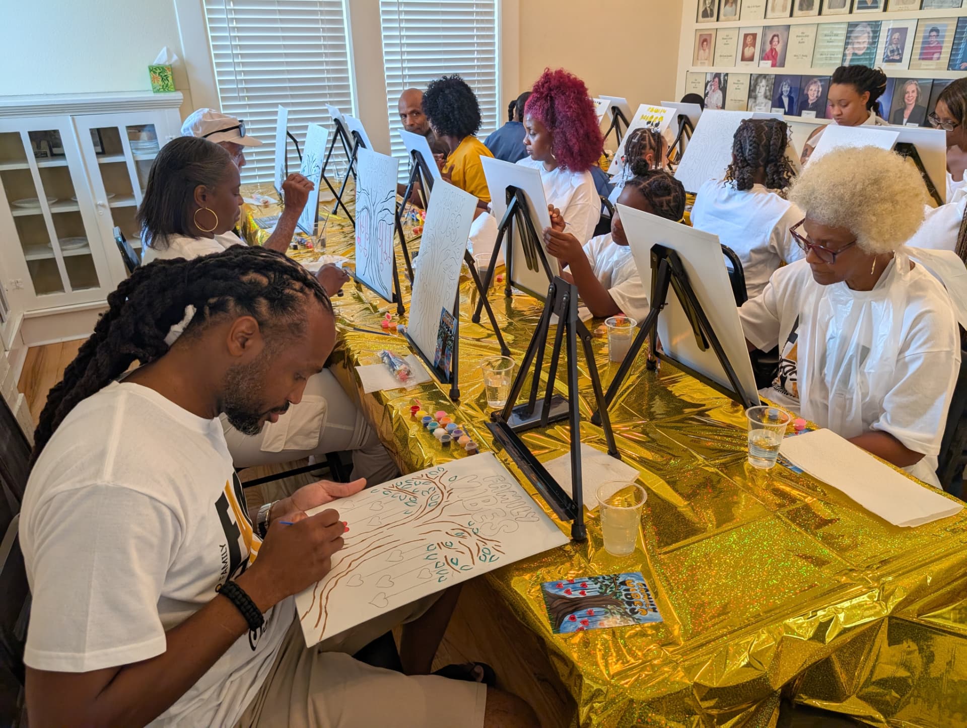 Family members of all ages working on Family Vibes canvases together