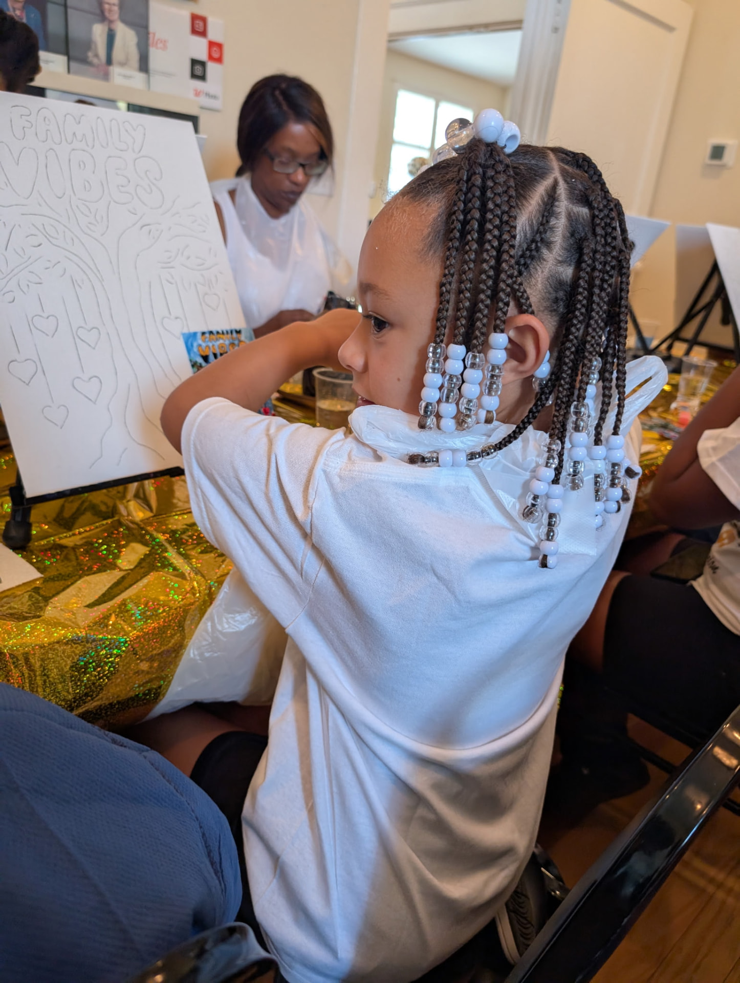 A young Chandler artist beside her Family Vibes canvas